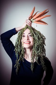 beautiful woman with carrots on hair on gray background