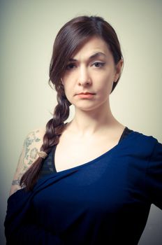 portrait of beautiful girl with long hair and blue sweater on gray background