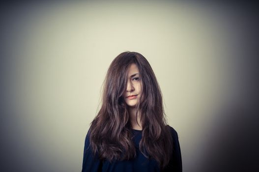 serious woman with long hair on vignetting background