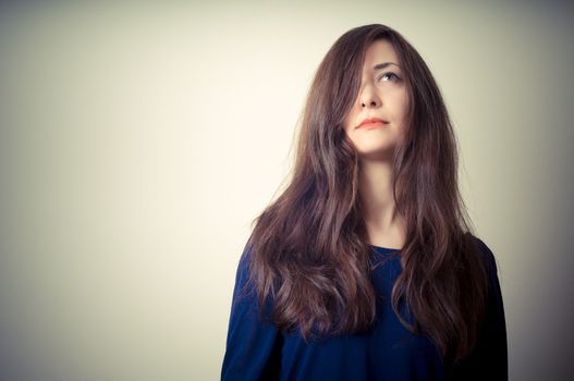 serious woman with long hair on vignetting background