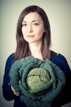 beautiful woman with savoy cabbage on gray background