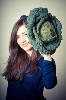 beautiful woman with savoy cabbage on gray background