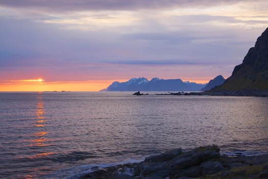 Scenic midnight sun over the ocean on Lofoten islands in Norway during polar day