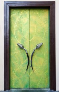 Plush green door with his hands in a brown frame
