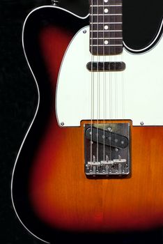 Musical concept electric guitar on a black background.