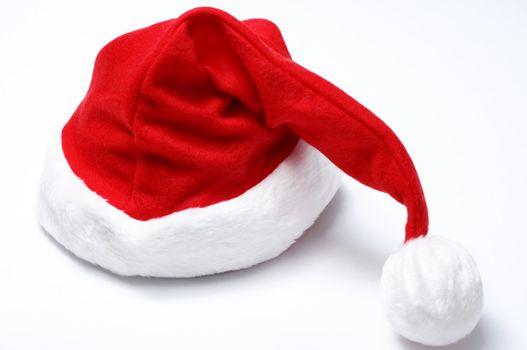 A Christmas Santa hat on an off-white surface, with visible soft shadows.