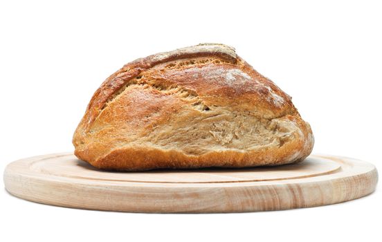 Side view (eye level) of a loaf of crusty wholemeal bread on a light wood chopping board.  Isolated on white background with shadows visible.