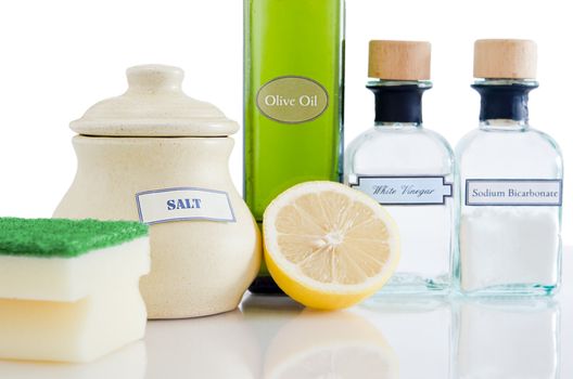 A range of natural, non-toxic cleaning products in containers on a shiny reflective surface with a white background.