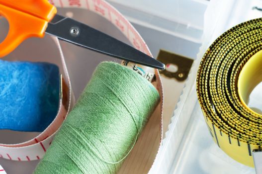 Sewing items in the plastic compartments of a sewing box.  Shot close up and from above.