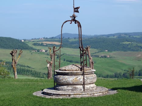 old well on the background of the Tuscan landscape