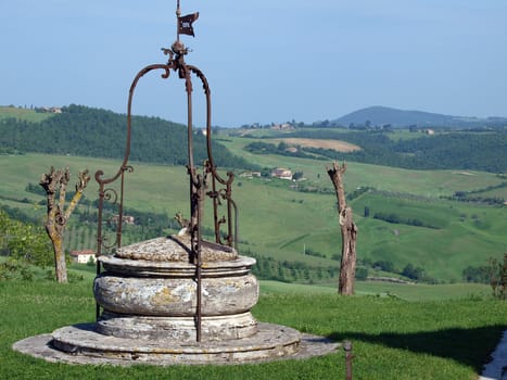 old well on the background of the Tuscan landscape