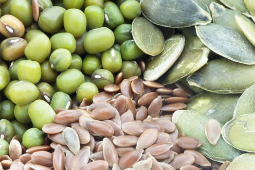 Close up of mung beans, linseeds (flax seeds) and pumpkin seeds, filling frame.