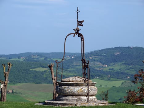 old well on the background of the Tuscan landscape