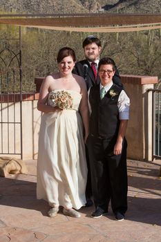 Smiling gay couple at wedding with rabbi
