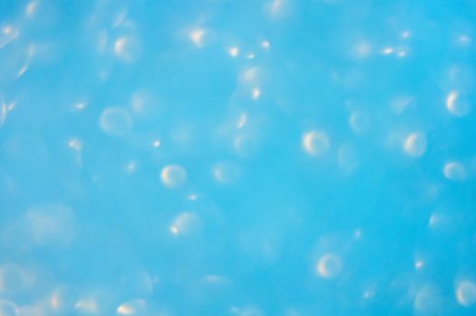 A soft photographed bokeh background in light blue with white lights creating an underwater bubble effect.