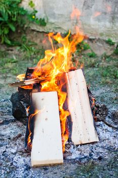 A campfire on the grasse, with boards