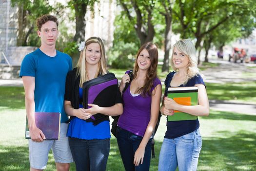 Group portrait of four college students on campus