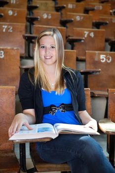 Portrait of sweet young girl attending lecture at university hall