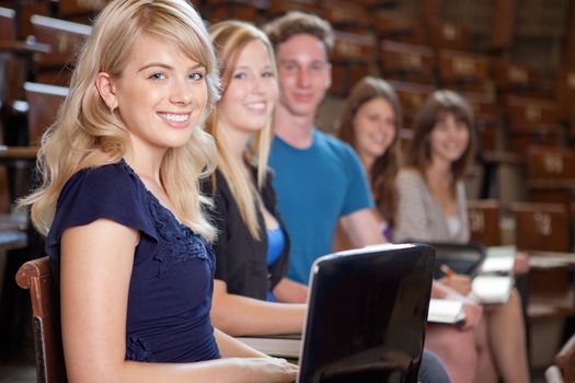Group of students looking at camera in a university lecture hall