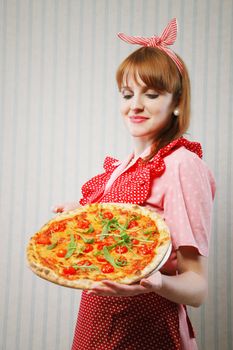 Young housewife holding a vegetarian pizza for lunch