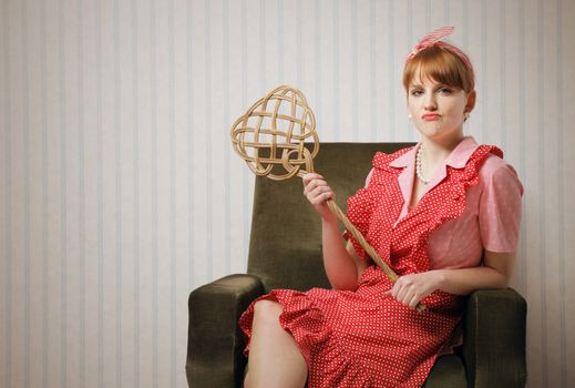 Ironic portrait of a housewife retro sitting in an armchair