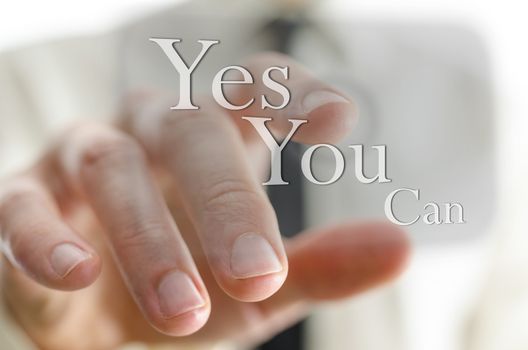 Male finger pointing at a Yes you can sign on a virtual screen.