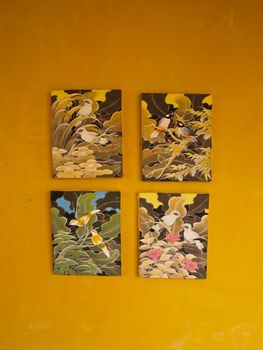 Four bird painting frames on yellow wall