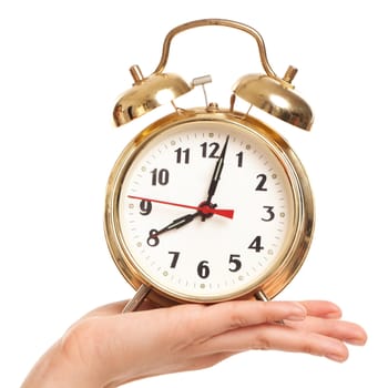 Alarm clock in woman's hand isolated over white background
