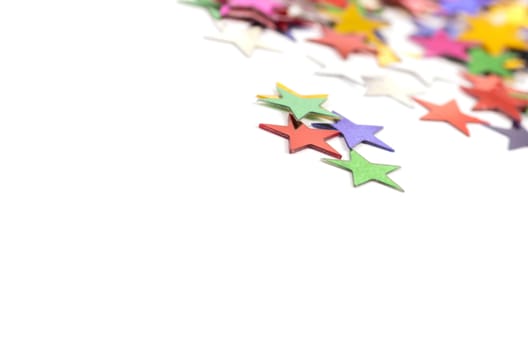 Christmas decoration of colored confetti stars against white background