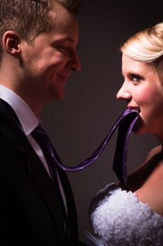 Beautiful young bride holding her groom on a leash