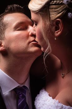 young couple in wedding wear kissing