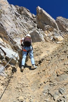 female climber on Bepi Zac via ferrata, italian Dolomites