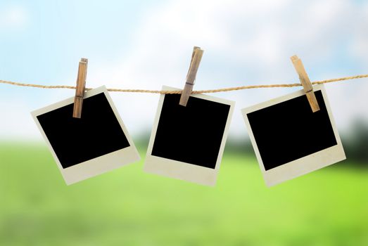 Three blank instant photos hanging on the clothesline