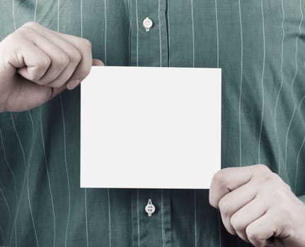 Closeup of businessman's hand holding up card