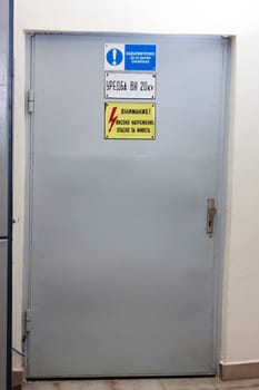 Industrial door with high voltage warning sign