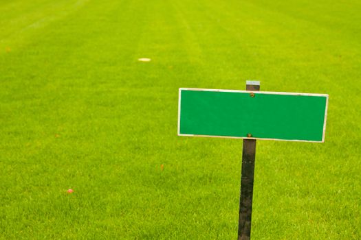 Green grass with a sign, horizontal shot with copy space