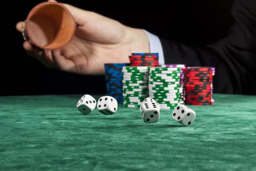 A businessman rolling the dice in a gambling game.