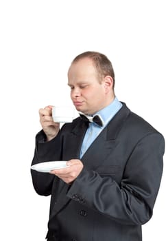 A young man in a suit drinking tea isolated