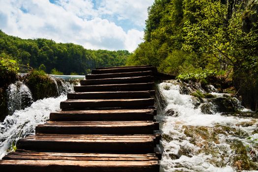 Wet wooden stairs with whitewater and forest