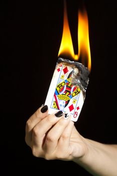 The queen of clubs is burning the queen of diamonds.