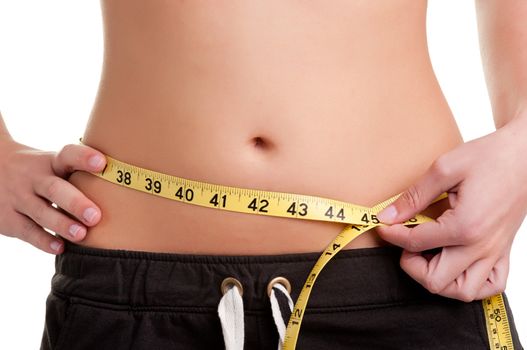 Woman measuring her waist with a yellow measuring tape, isolated in white