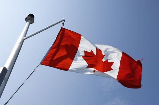 Canadian flag waving in the wind. On a ship mast	