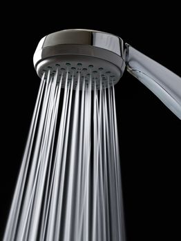 Detailed shot of a shower-head with shower spray. Vertical orientation.
The jets of water are taken at a slow speed por provide movement.