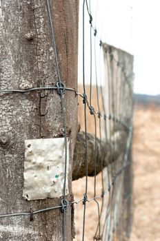 Wooden fence with metal plate against blurry background