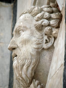 Siena - Head carved in marble on the facade of the Baptistery