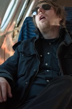 Portrait of a young man sleeping in a seat of an airplane