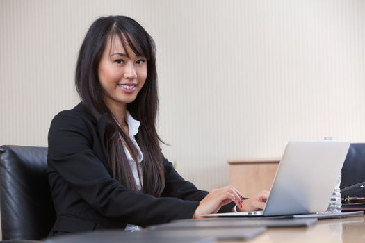 Portrait of beautiful young business woman working on laptop