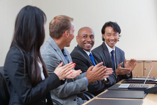 Business people applauding and smiling in presentation room