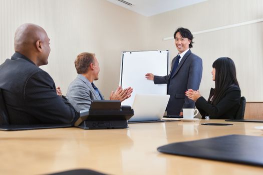 Smiling business man giving a presentation to associates