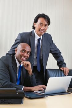 Portrait of smiling business people working on laptop